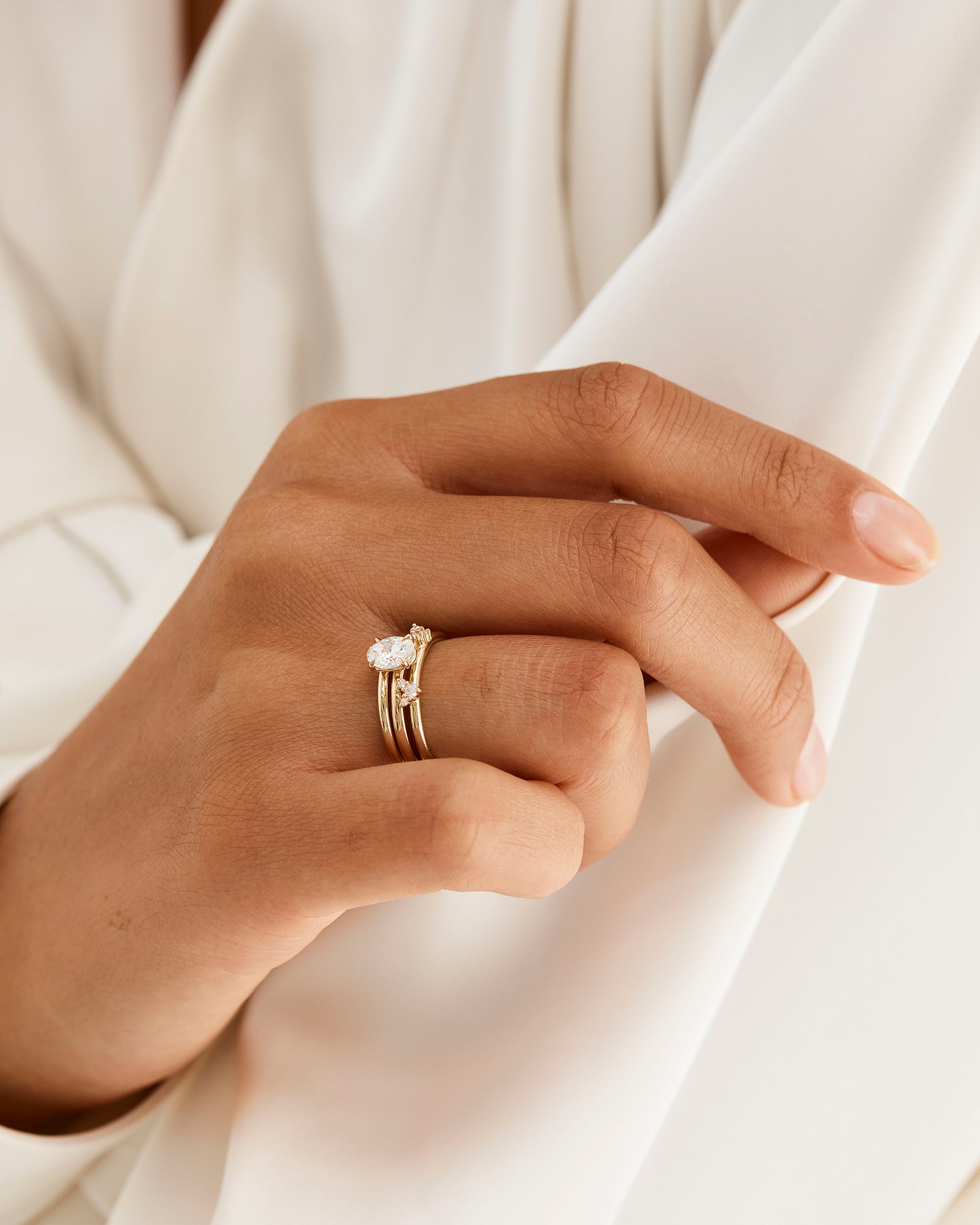 Model wears a diamond cluster ring with a classic diamond signature solitaire