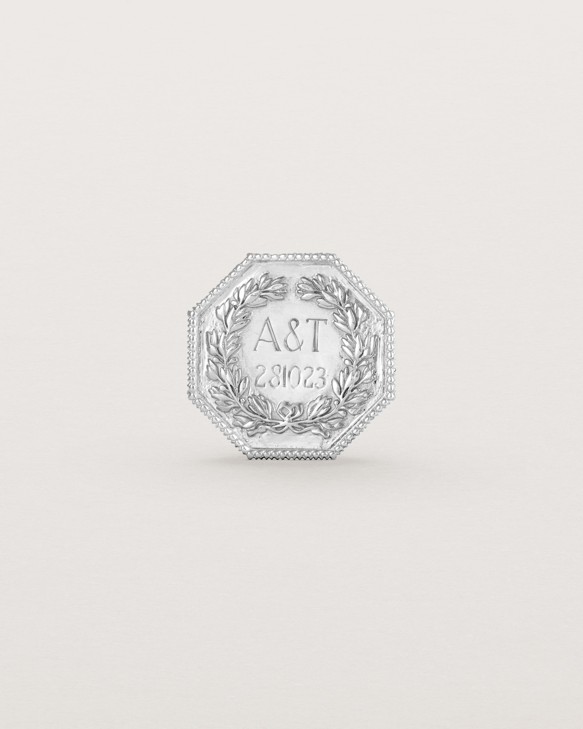 Sterling silver six pence coin engraved with a crest and initials