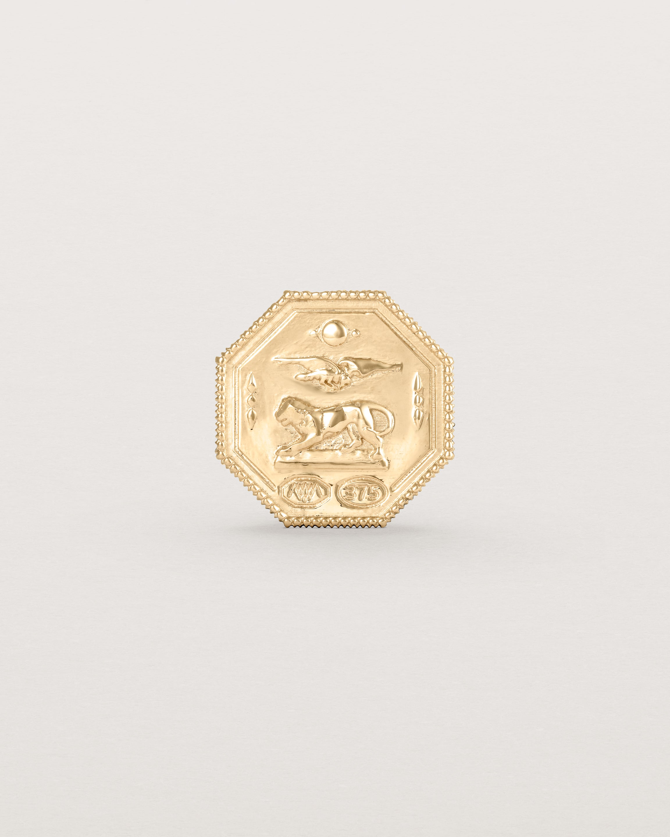 yellow gold six pence coin engraved with a crest and initials