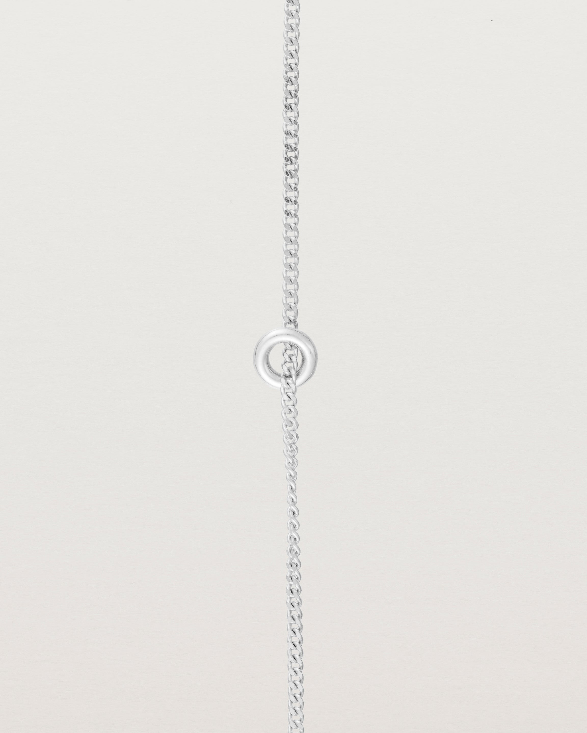 close up view of the Aether Bracelet showing one round charm in sterling silver