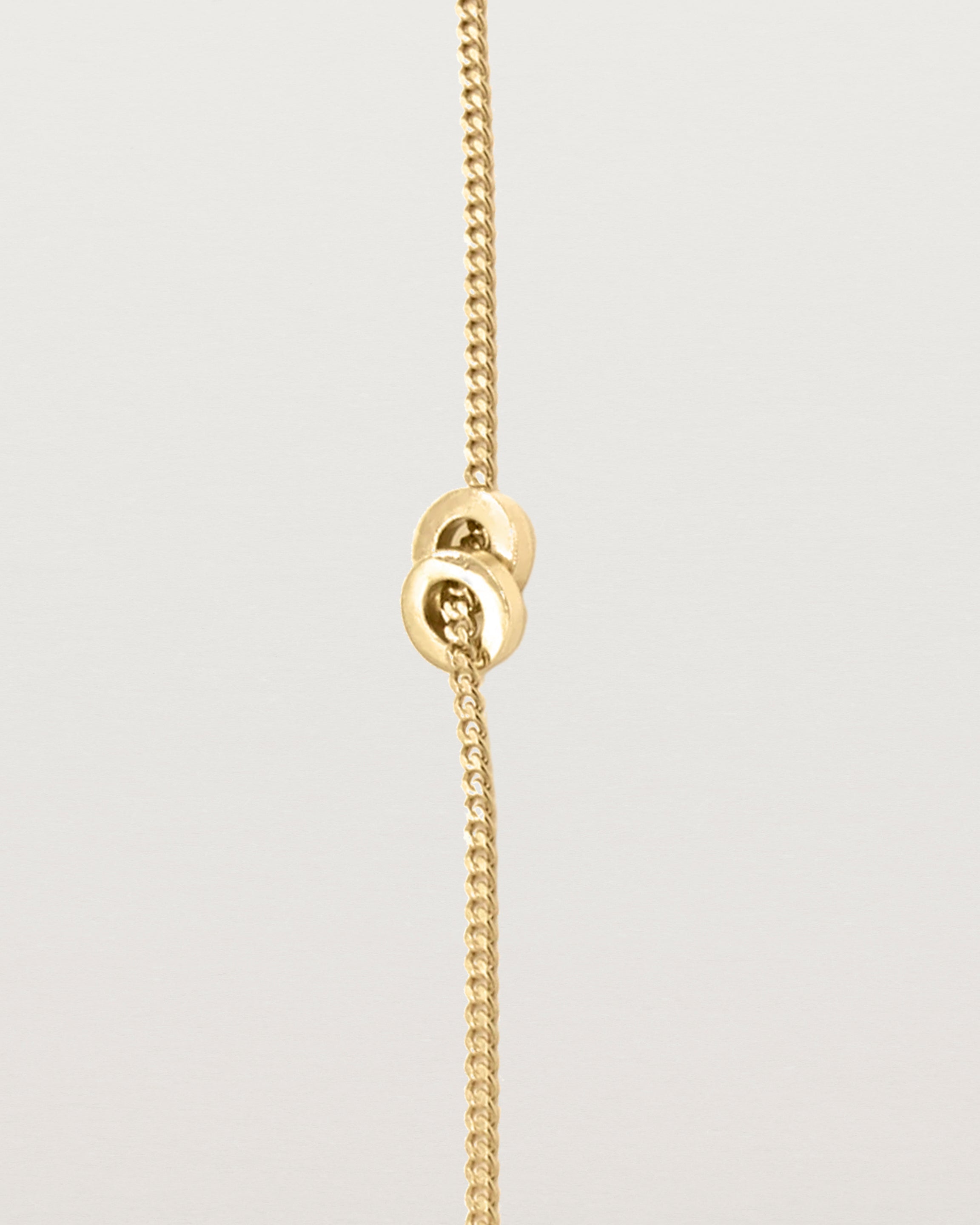 A fine yellow gold chain bracelet featuring a square circular charm
