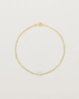 A yellow gold chain bracelet featuring a single white old cut diamond