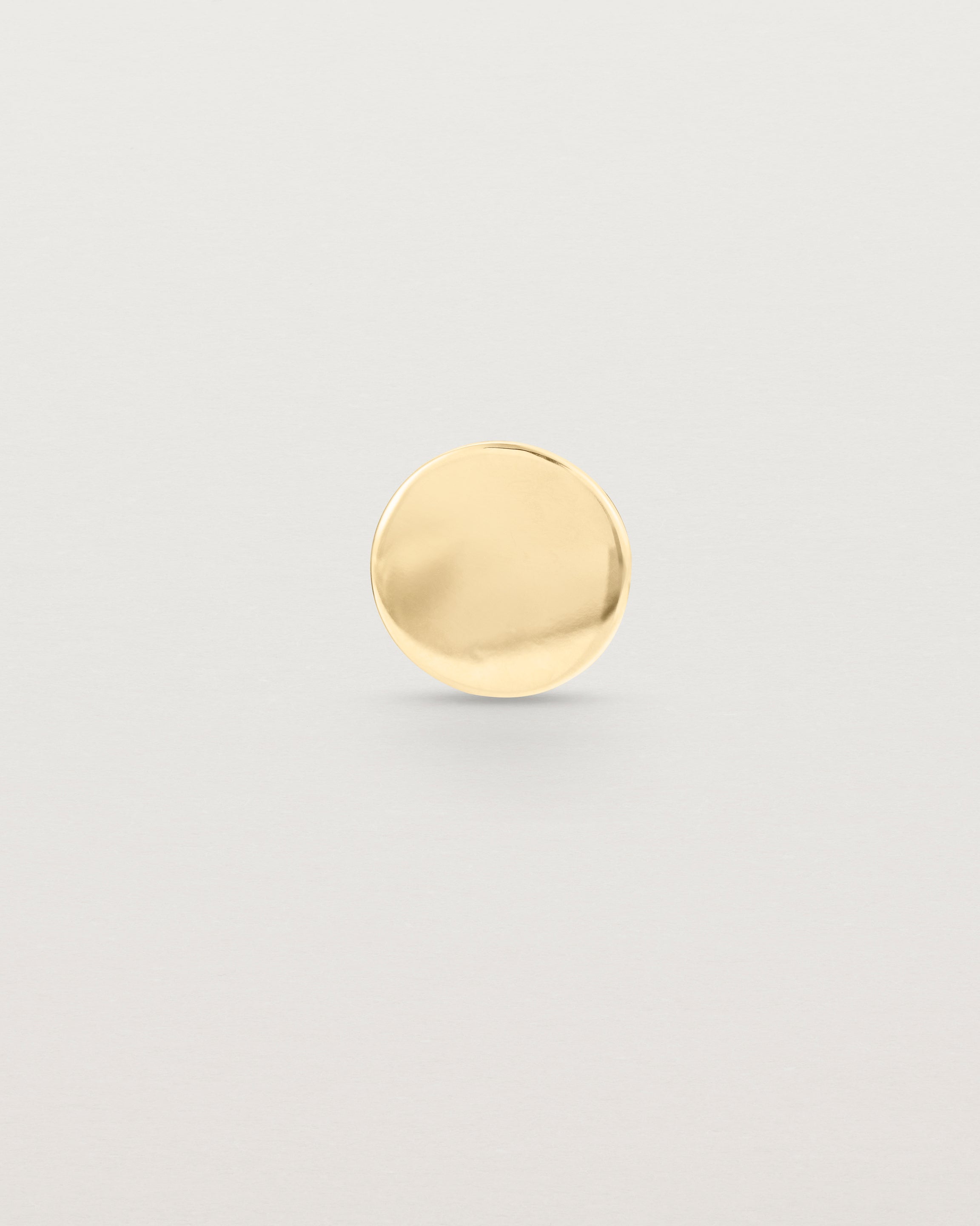 A round polished yellow gold lapel pin