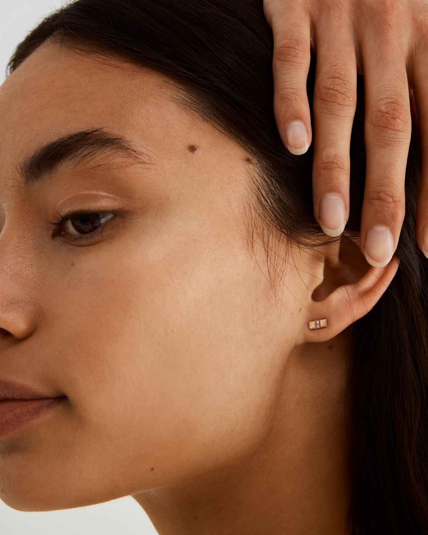 A woman wearing the Antares Studs in Diamonds