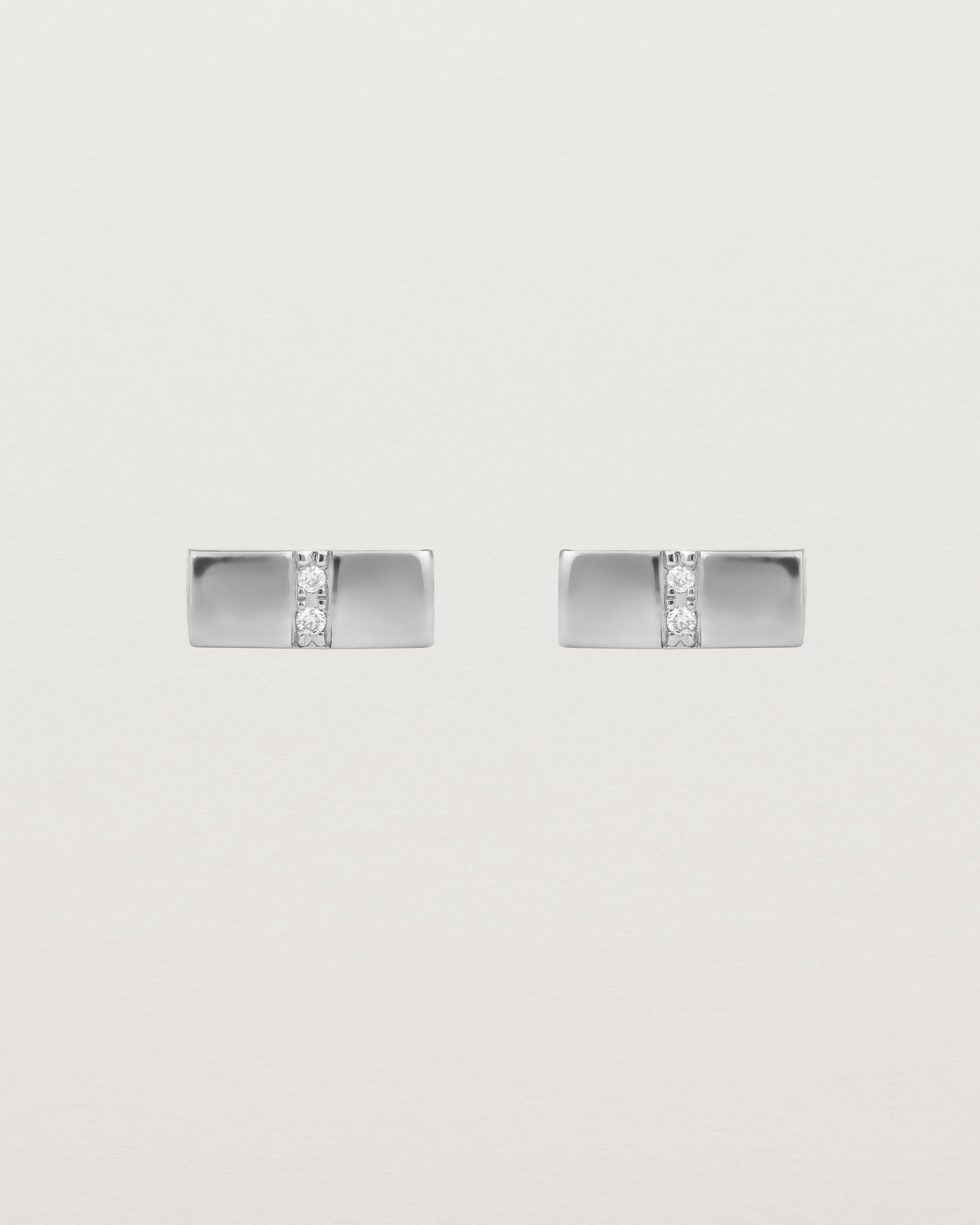 A pair of small silver rectangle studs featuring two white diamonds set in the centre