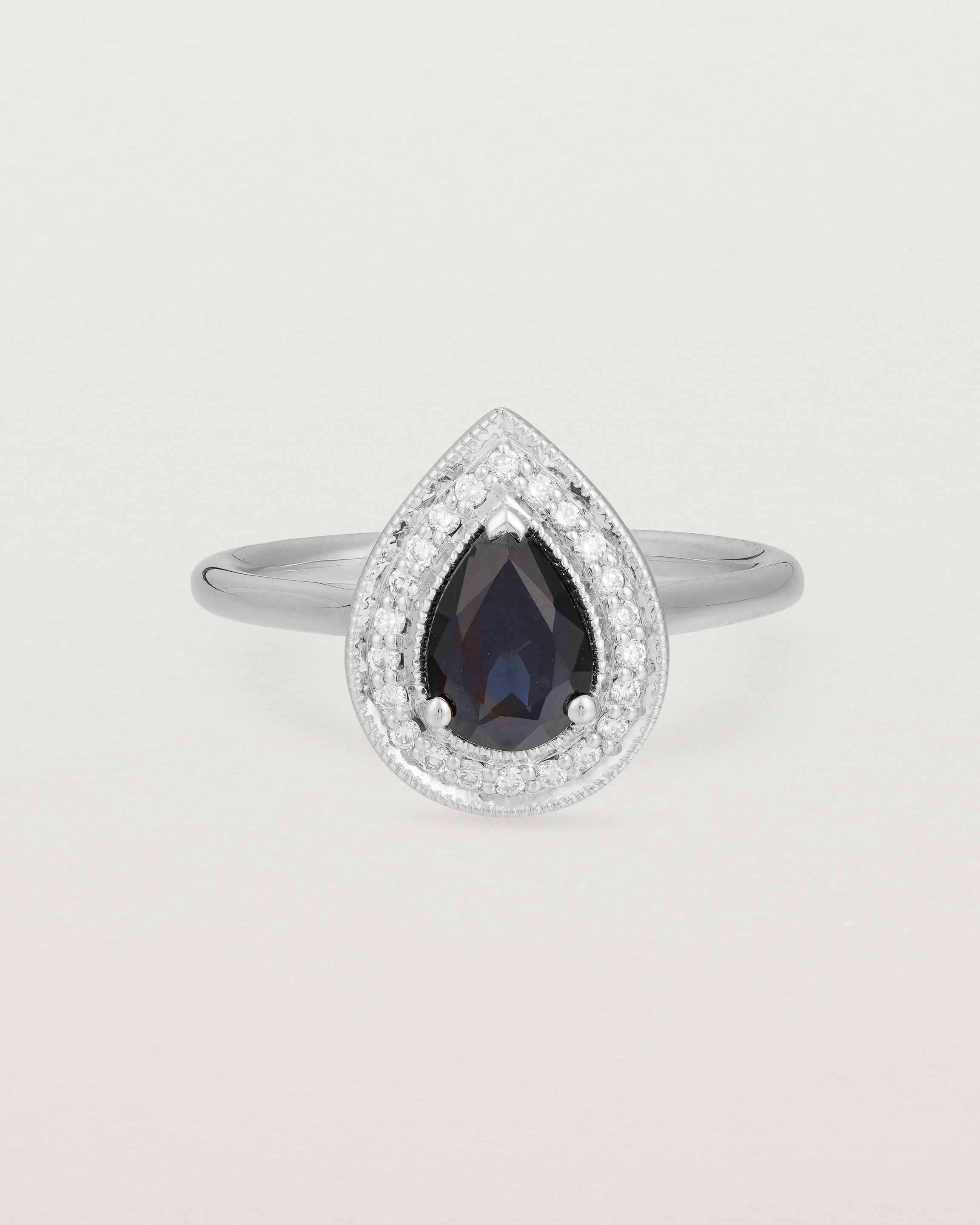 front view pear halo ring featuring a pear cut australian blue sapphire and a halo of white diamonds in white gold
