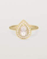 Front view pear halo ring featuring a pear cut pale pink morganite and a halo of white diamonds in yellow gold