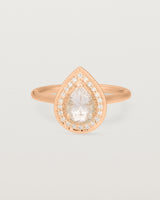 Front view pear halo ring featuring a pear cut pale pink morganite and a halo of white diamonds in rose gold