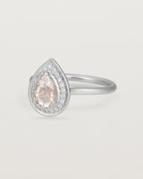 Side view pear halo ring featuring a pear cut pale pink morganite and a halo of white diamonds in white gold