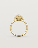 Standing view pear halo ring featuring a pear cut pale pink morganite and a halo of white diamonds in yellow gold
