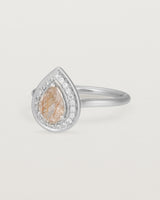 Side view pear halo ring featuring a pear cut rutilated quartz stone and a halo of white diamonds in white gold