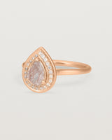 Side view pear halo ring featuring a pear cut rutilated quartz stone and a halo of white diamonds in rose gold