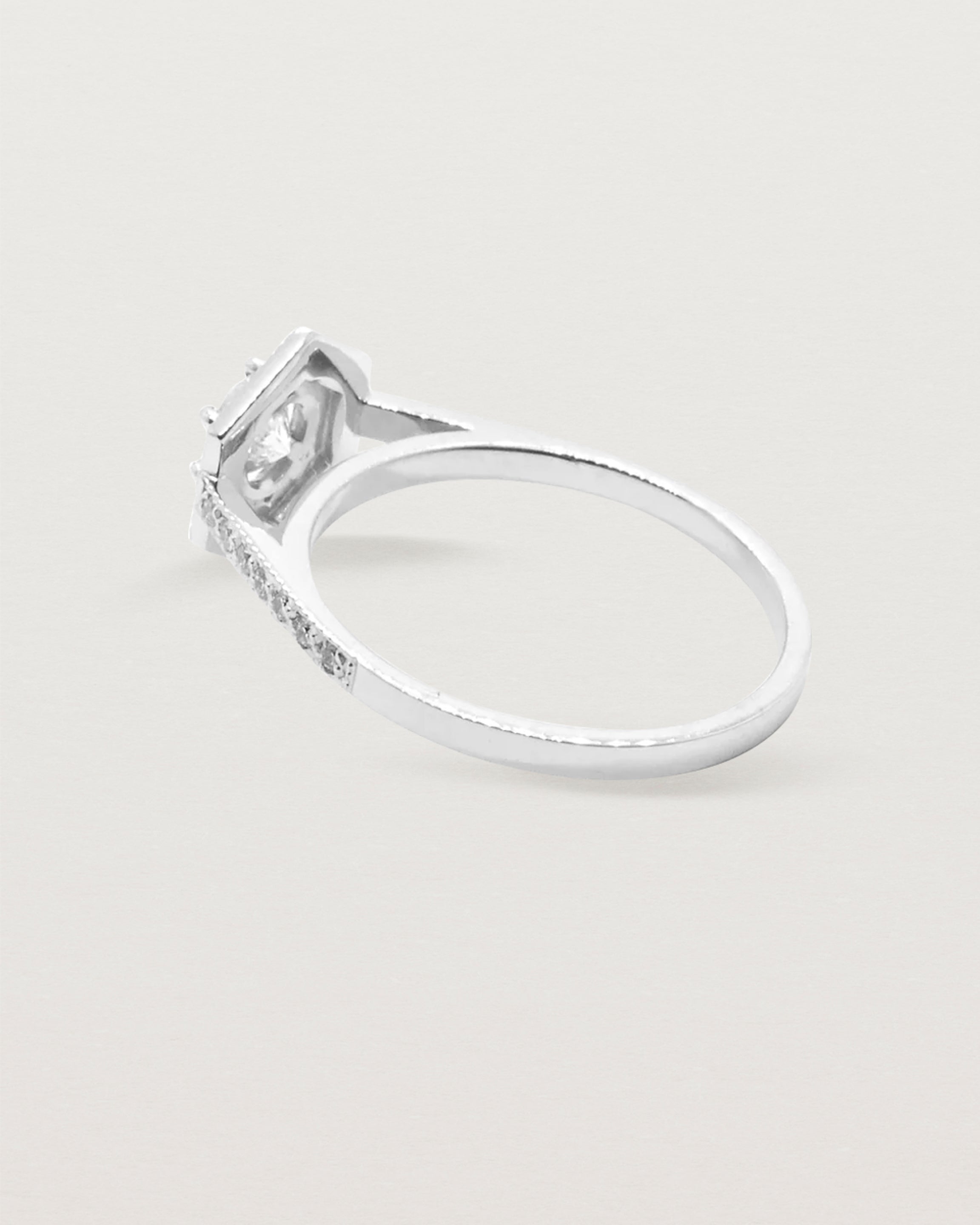 A hexagonal halo diamond ring featuring a central 0.32 carat round cut diamond and surrounded by a diamond halo.