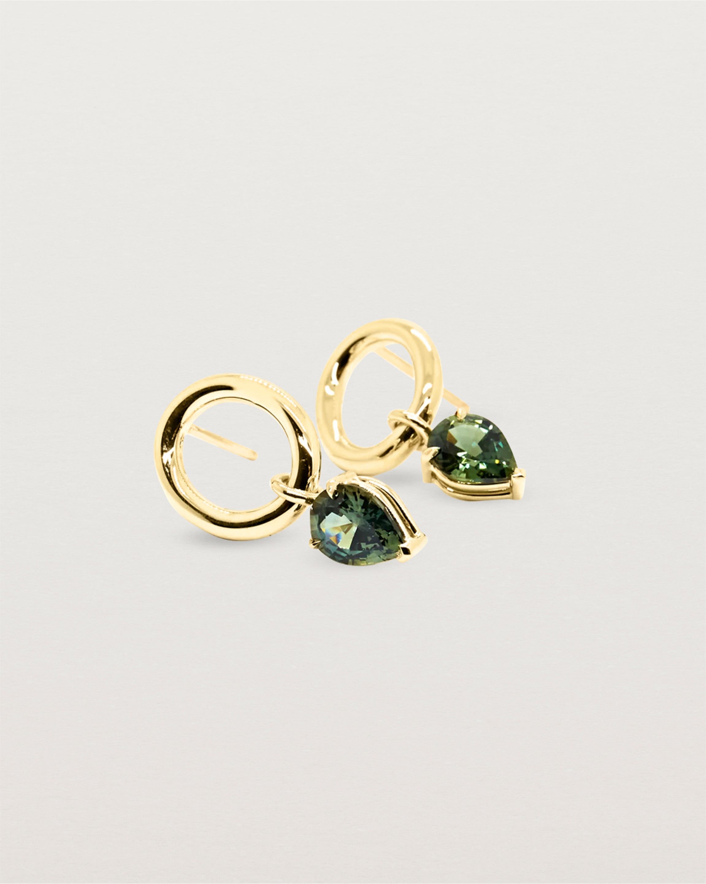 Delicately hanging, a three claw basket setting holding a stunning pair of Australian green sapphires.