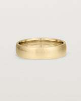 The front view of a 5mm wide heavy wedding ring in yellow gold. 