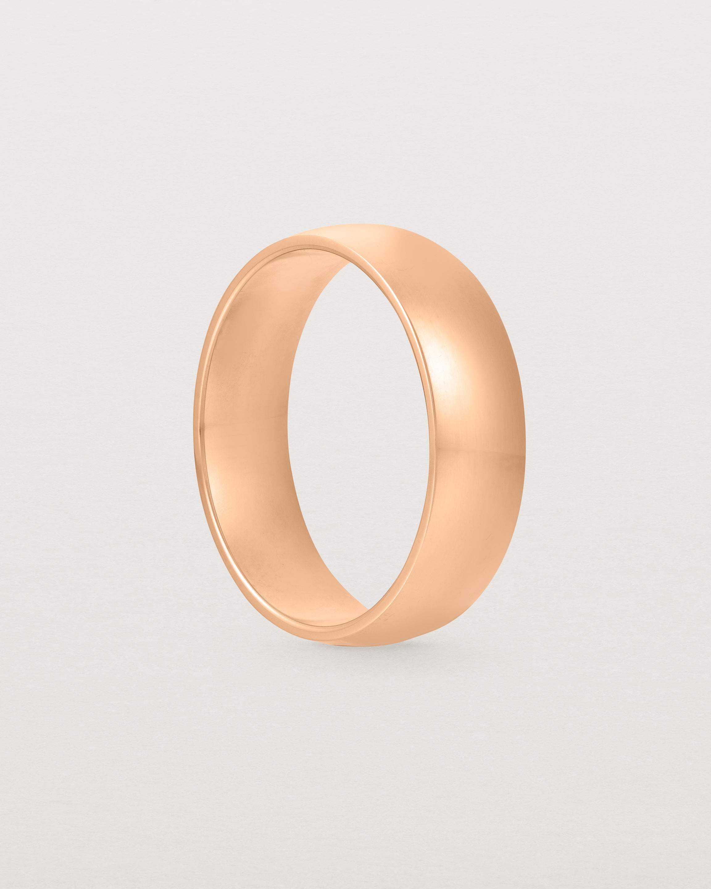 The front view of a 6mm wide heavy wedding ring in rose gold.