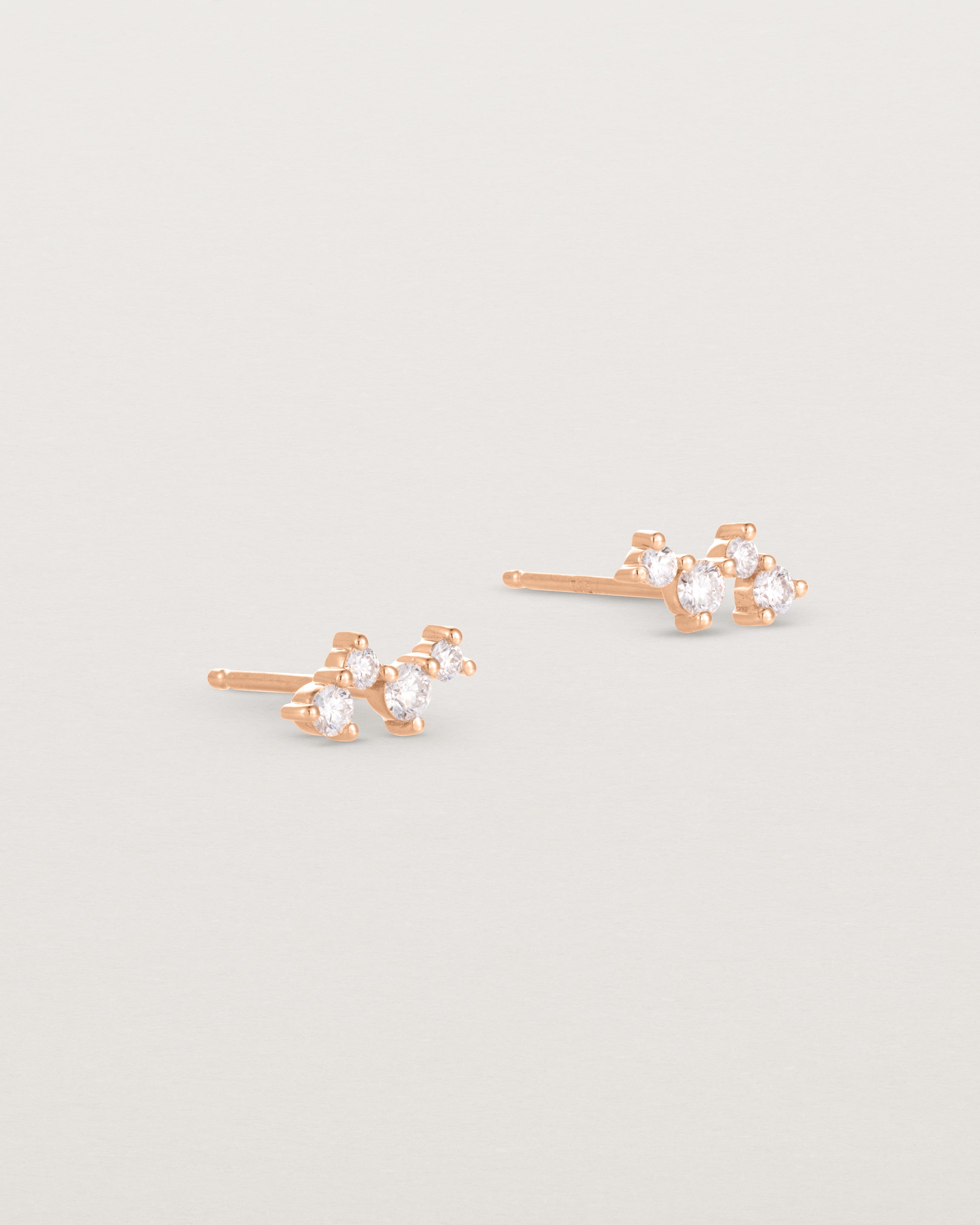 A pair of rose gold studs featuring a cluster of four diamonds