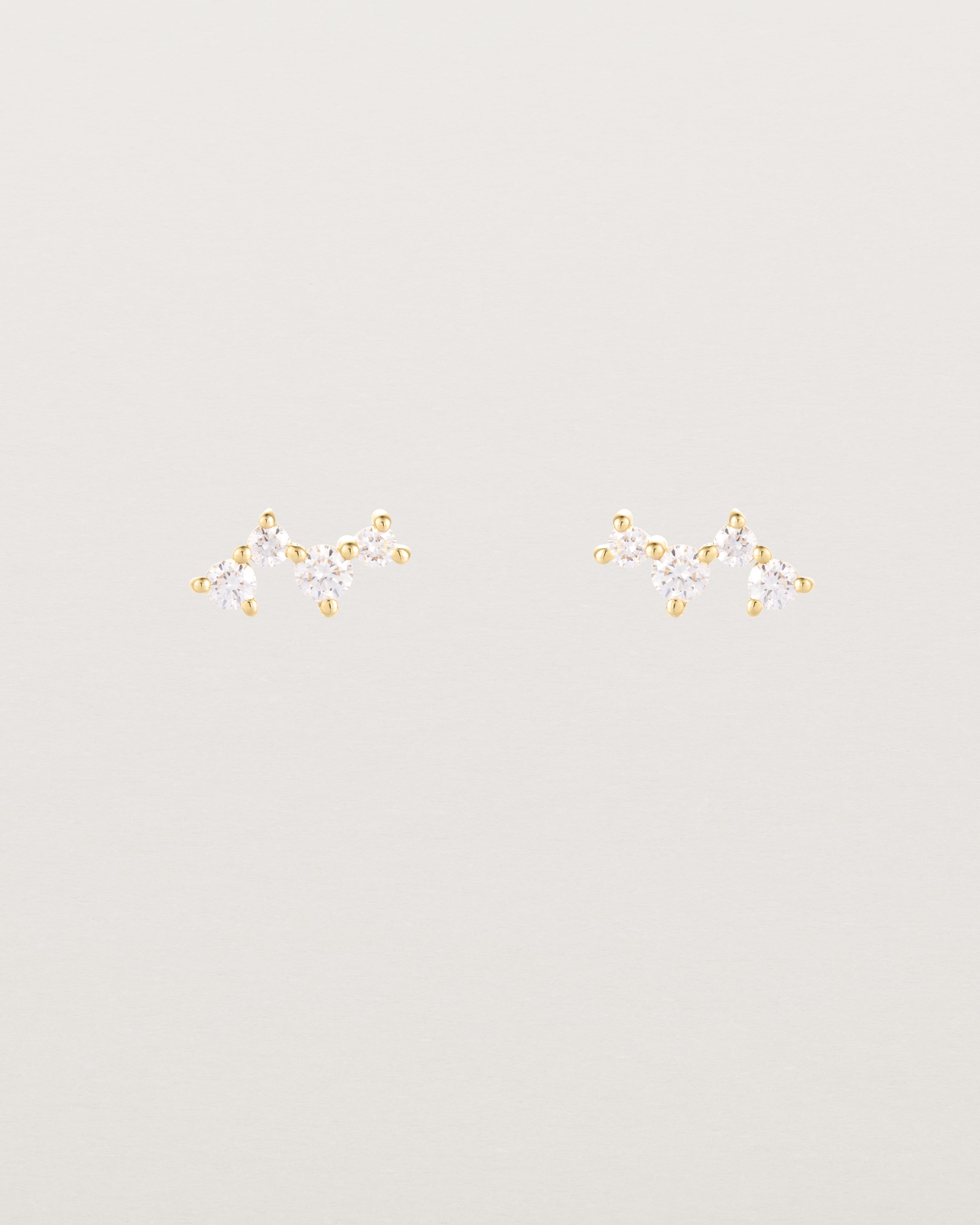 A pair of yellow gold studs featuring a cluster of four diamonds
