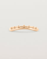 A gentle arc ring featuring dot detailing along the top of the arc, crafted in rose gold.
