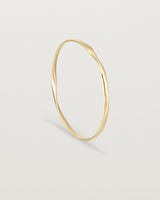 standing view of the ellipse bangle in yellow gold