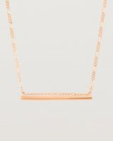 close up of Ellipse necklace with a rose gold bar hanging from a chain in rose gold
