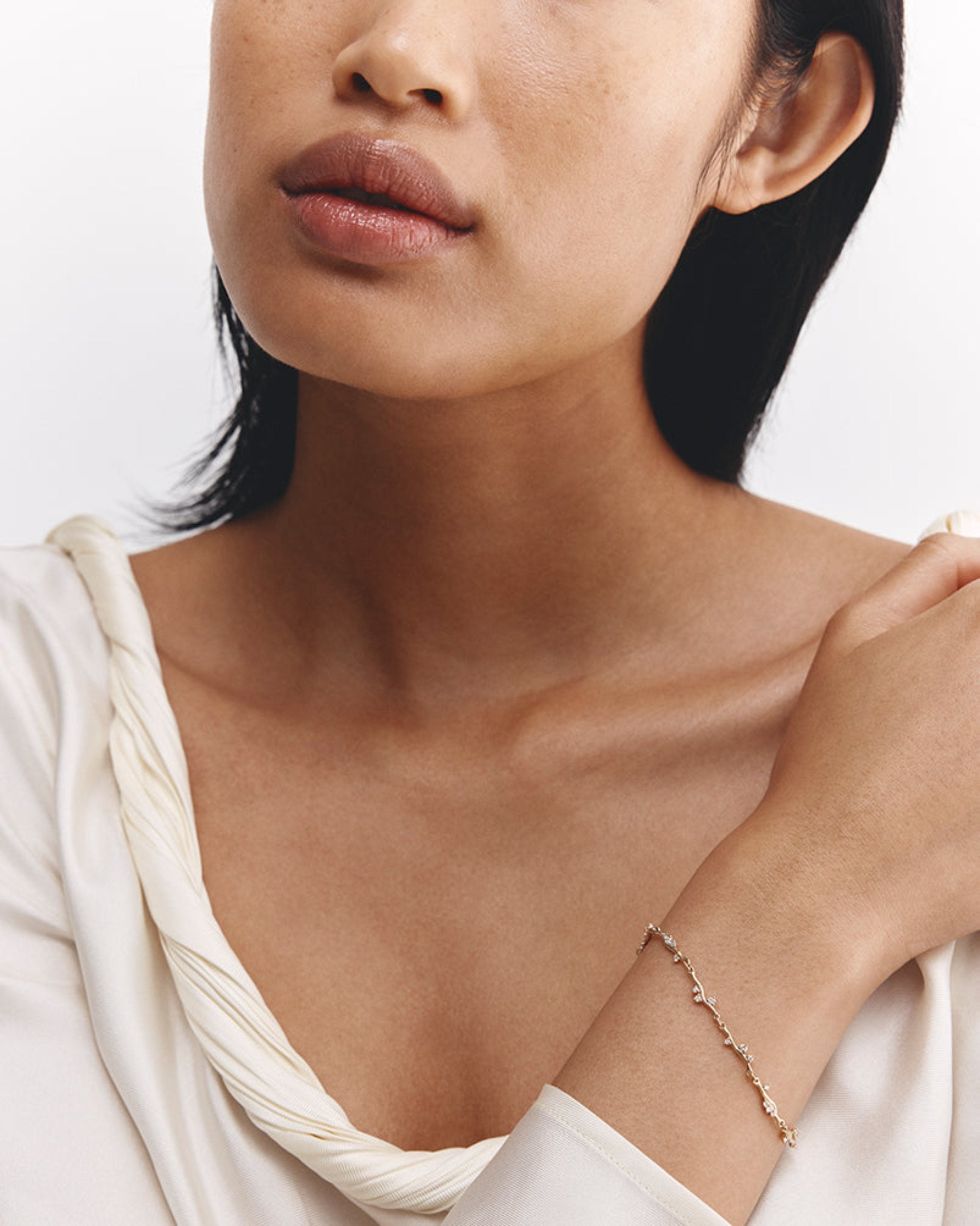 Model wearing ember bracelet with diamonds in yellow gold.