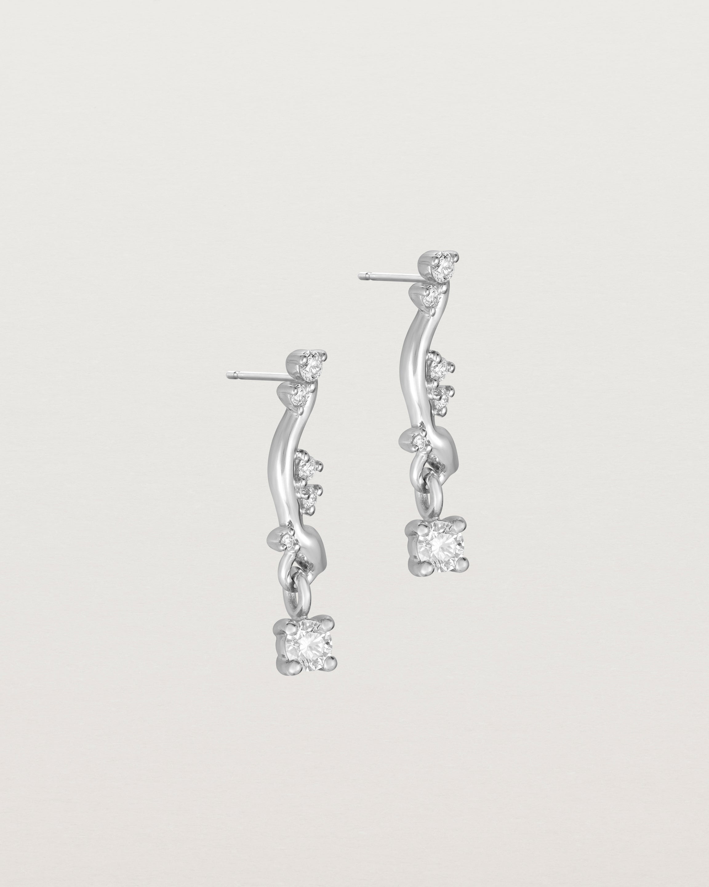 side image of diamond drop ember earrings in white gold.