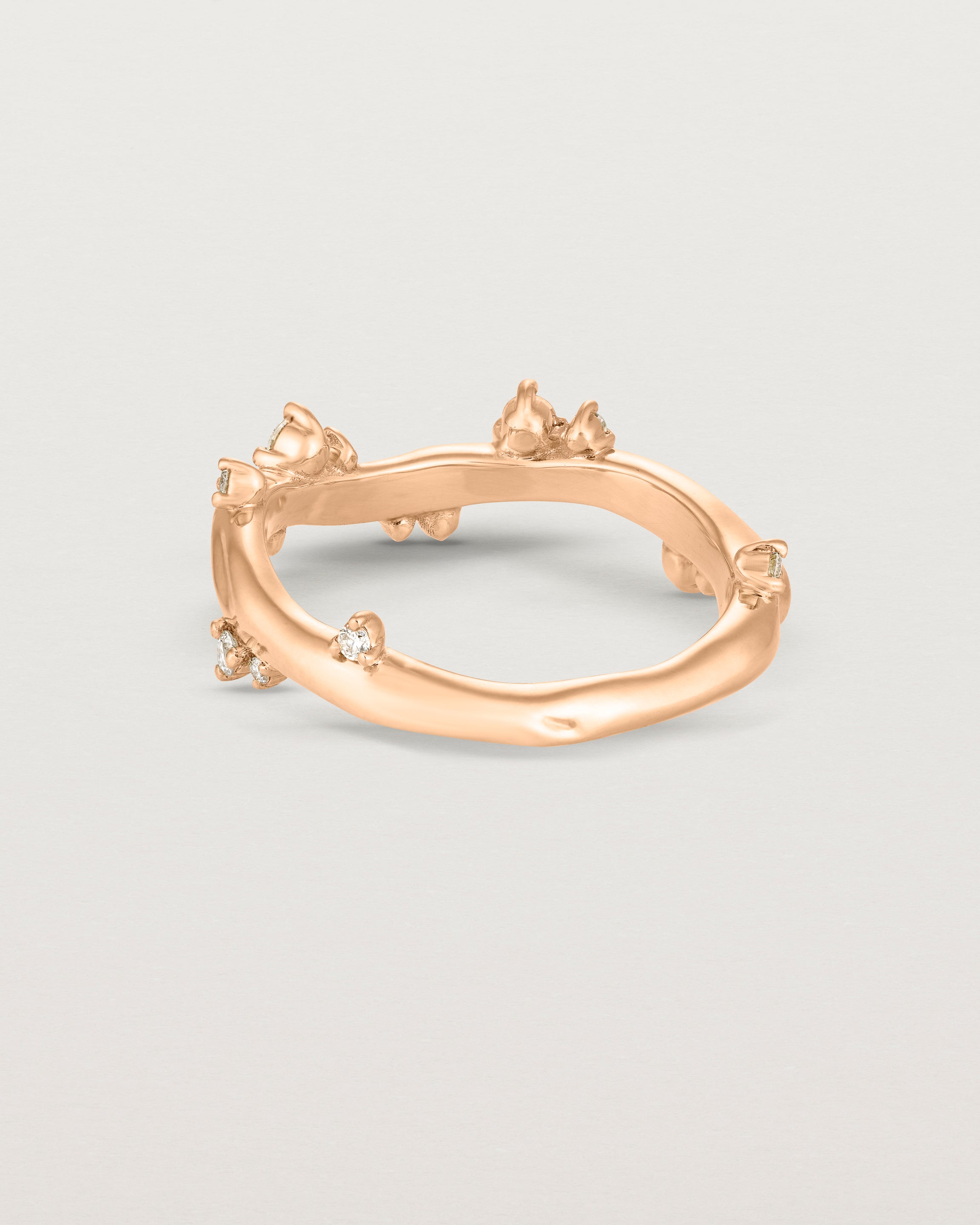 Product photo of the back in rose gold Ember ring with white diamonds scattered around the band.
