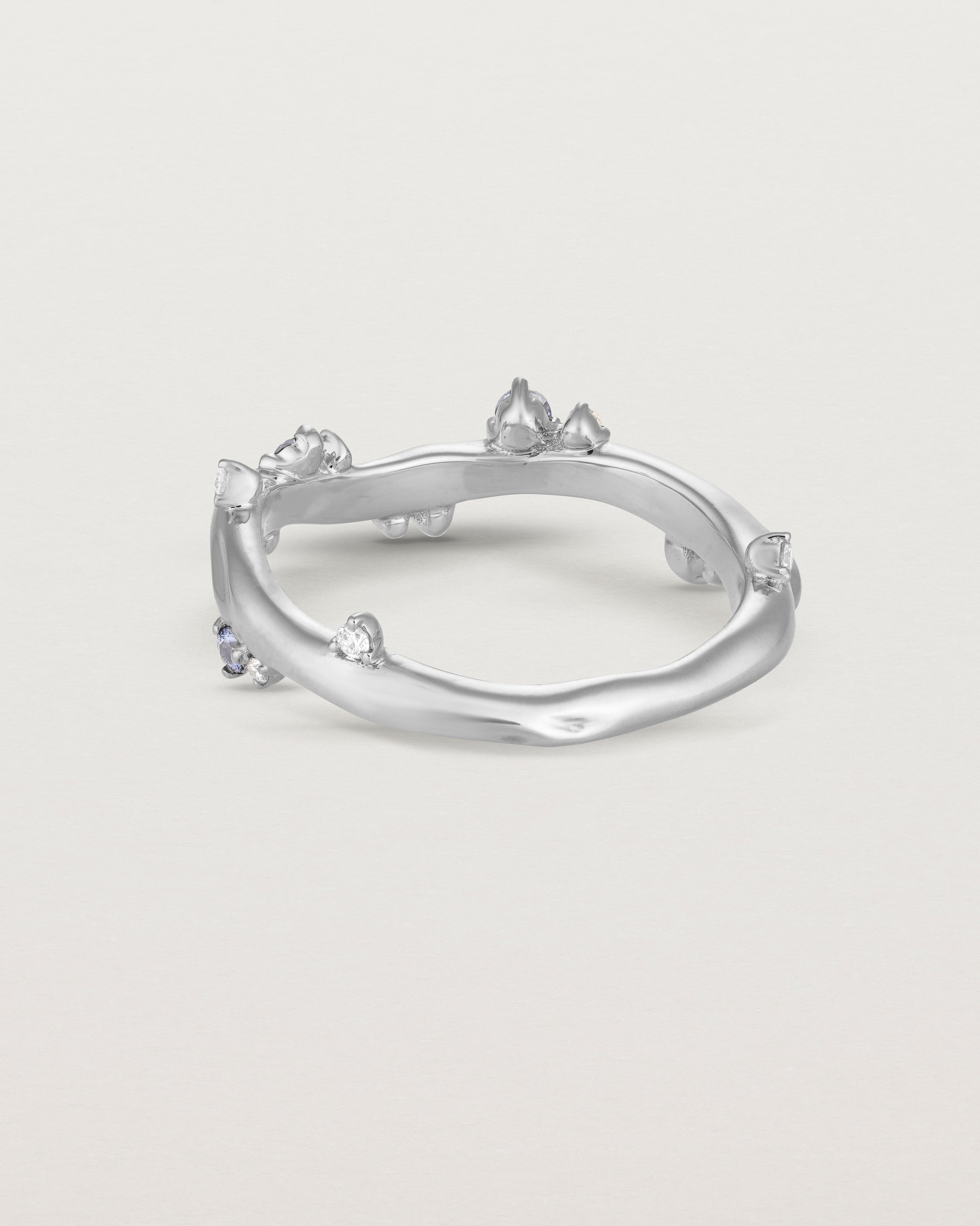 Back image of the Ember ring in white gold featuring a scattering of white diamonds and blue sapphires.