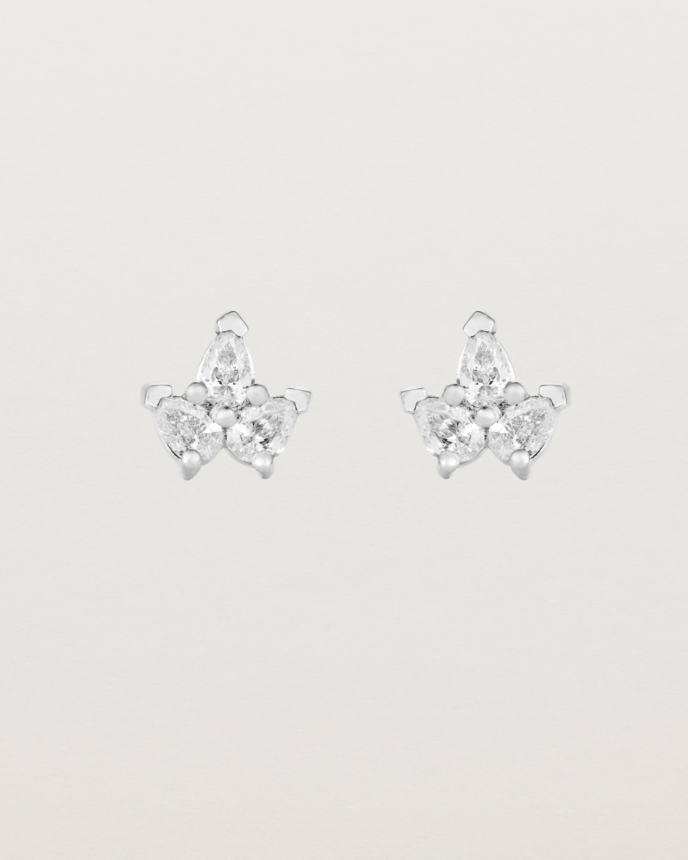 A pair of white gold studs featuring three pear shaped diamonds