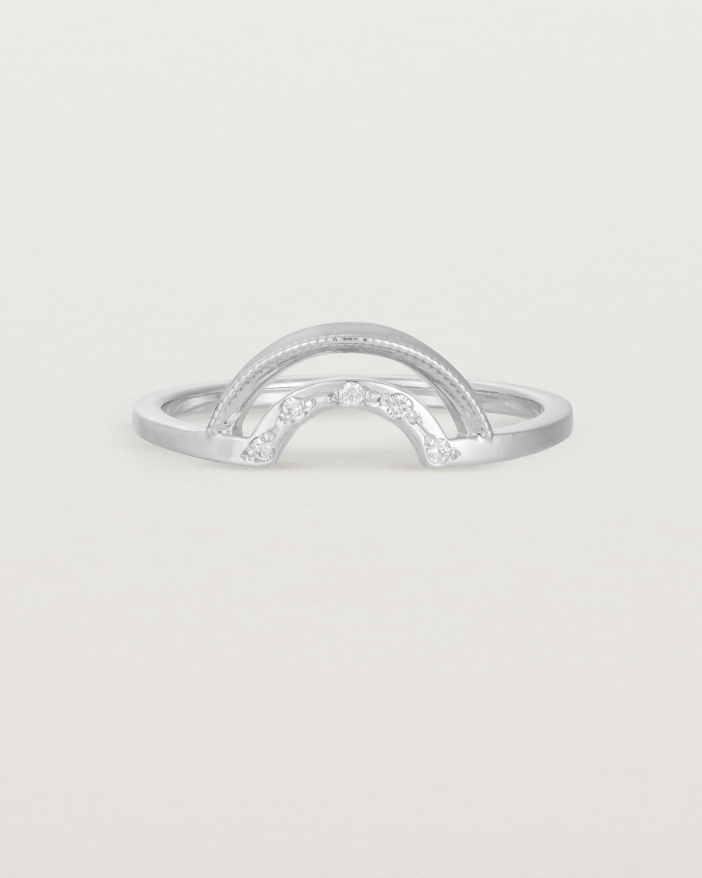 A double arc crown ring with white diamonds adoring the inner arc - crafted in white gold. 