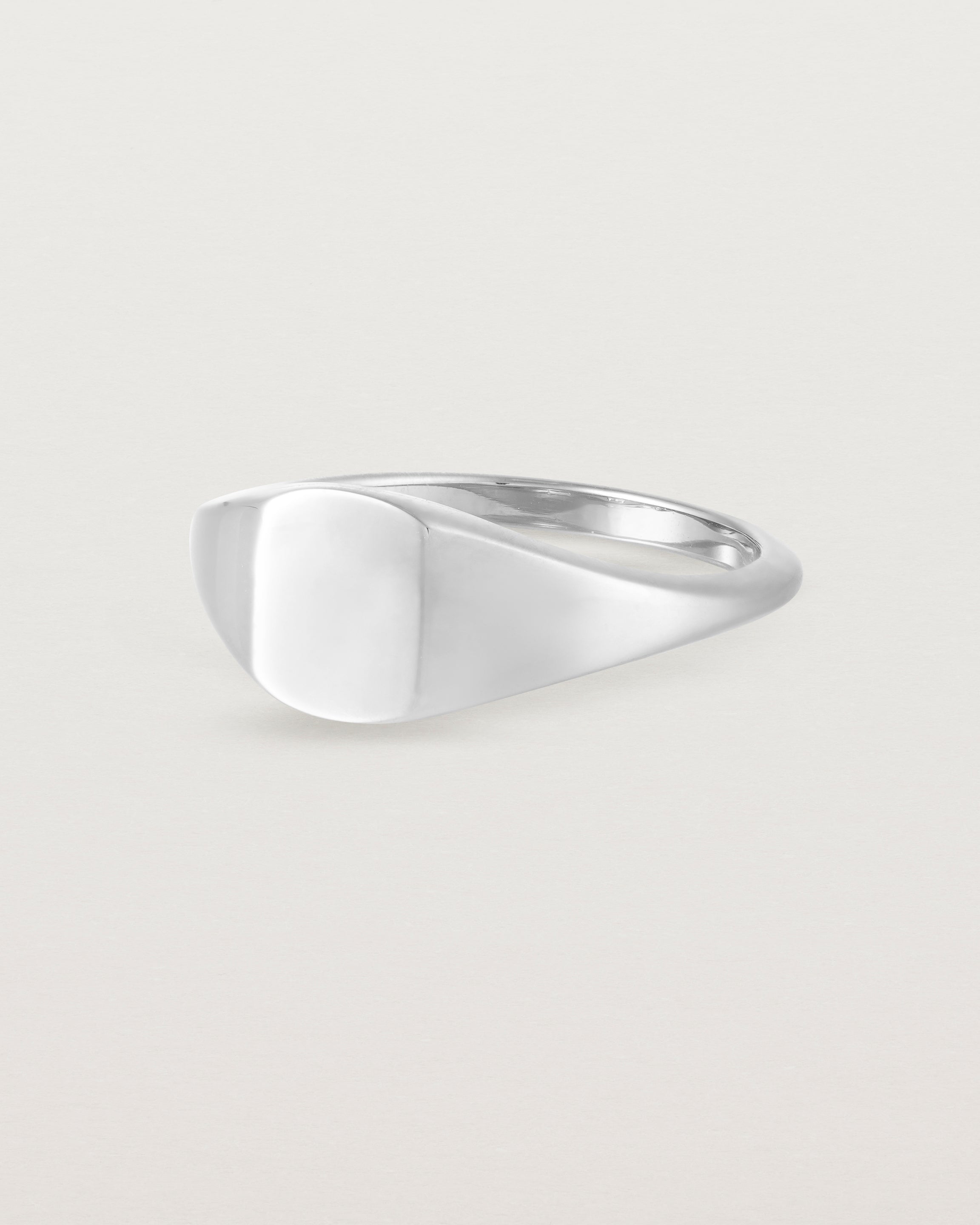 Angled view of a simple signet with an elongated rectangular face in white gold