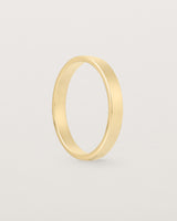 The side profile of our square, flat 3mm profile wedding band crafted in yellow gold