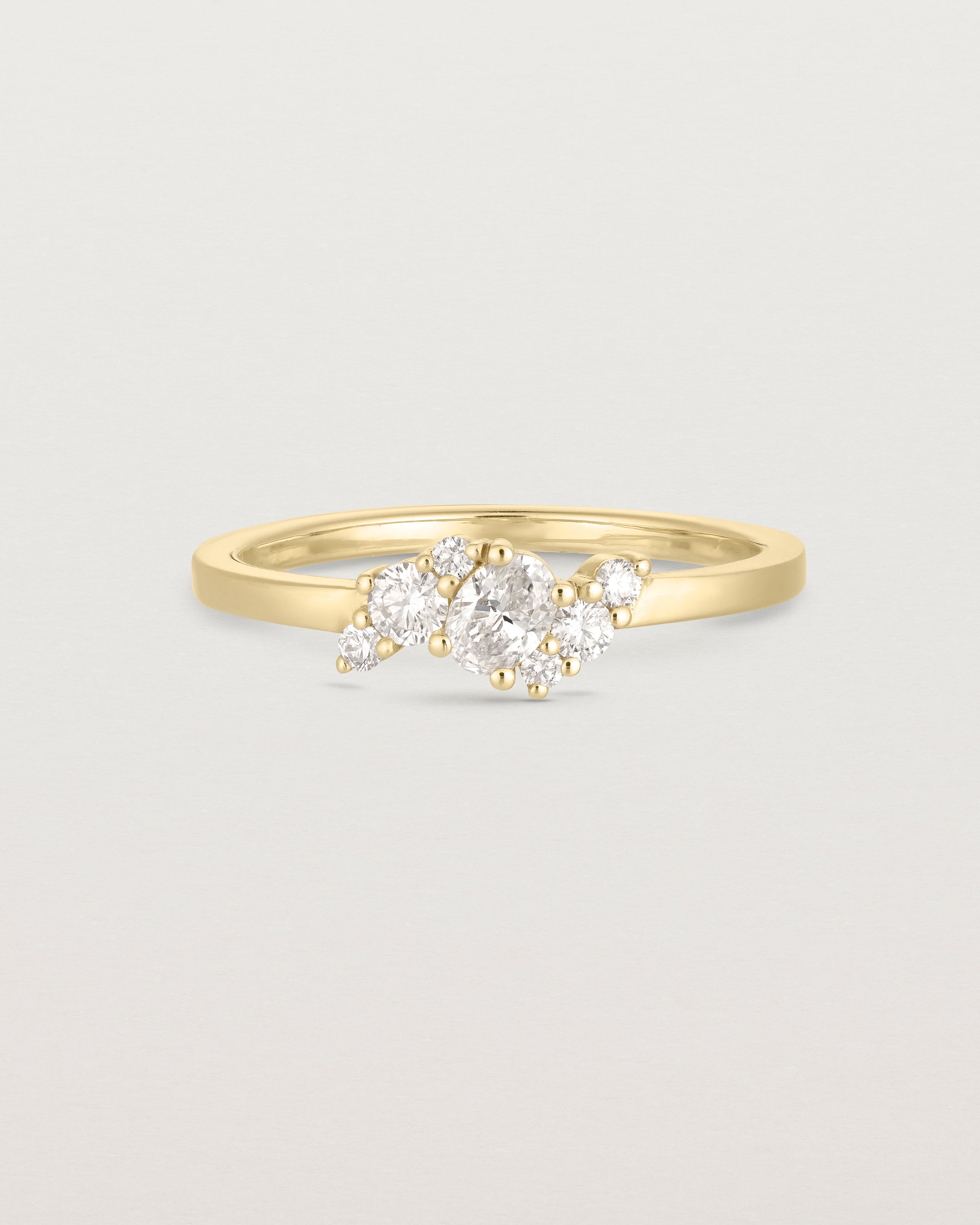 deep etched image of a yellow gold engagement ring with a cluster of 7 white diamonds