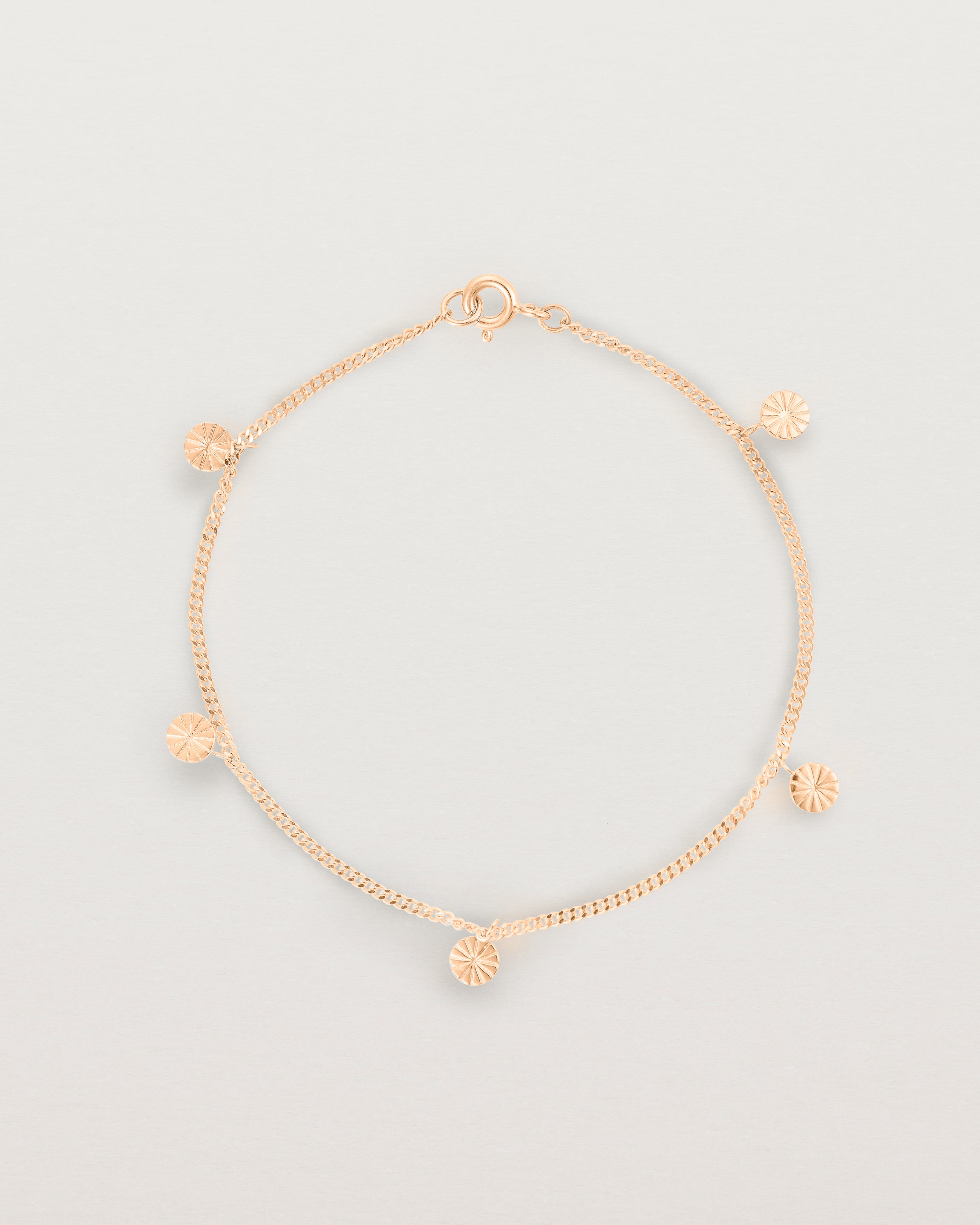 A rose gold chain bracelet with five circle charms