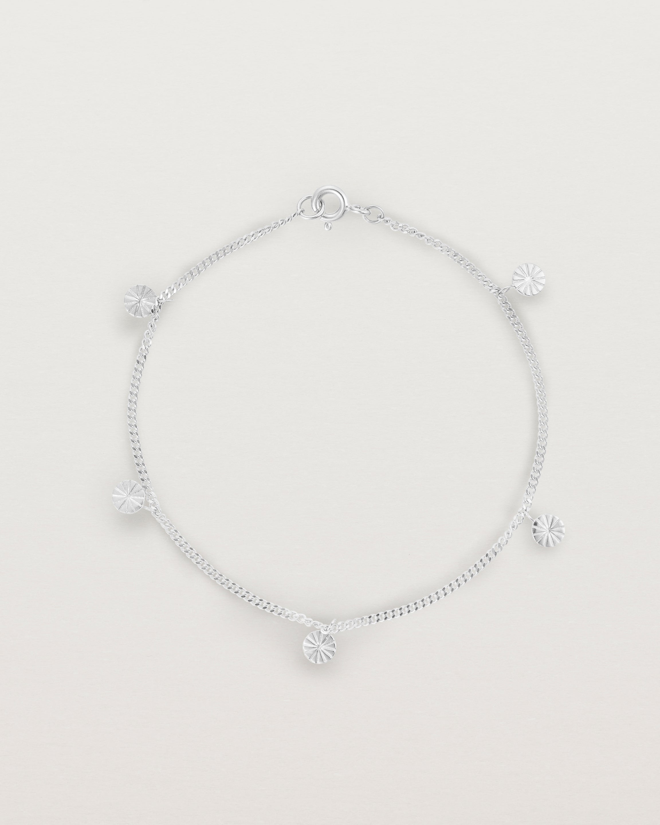 A silver chain bracelet with five circle charms
