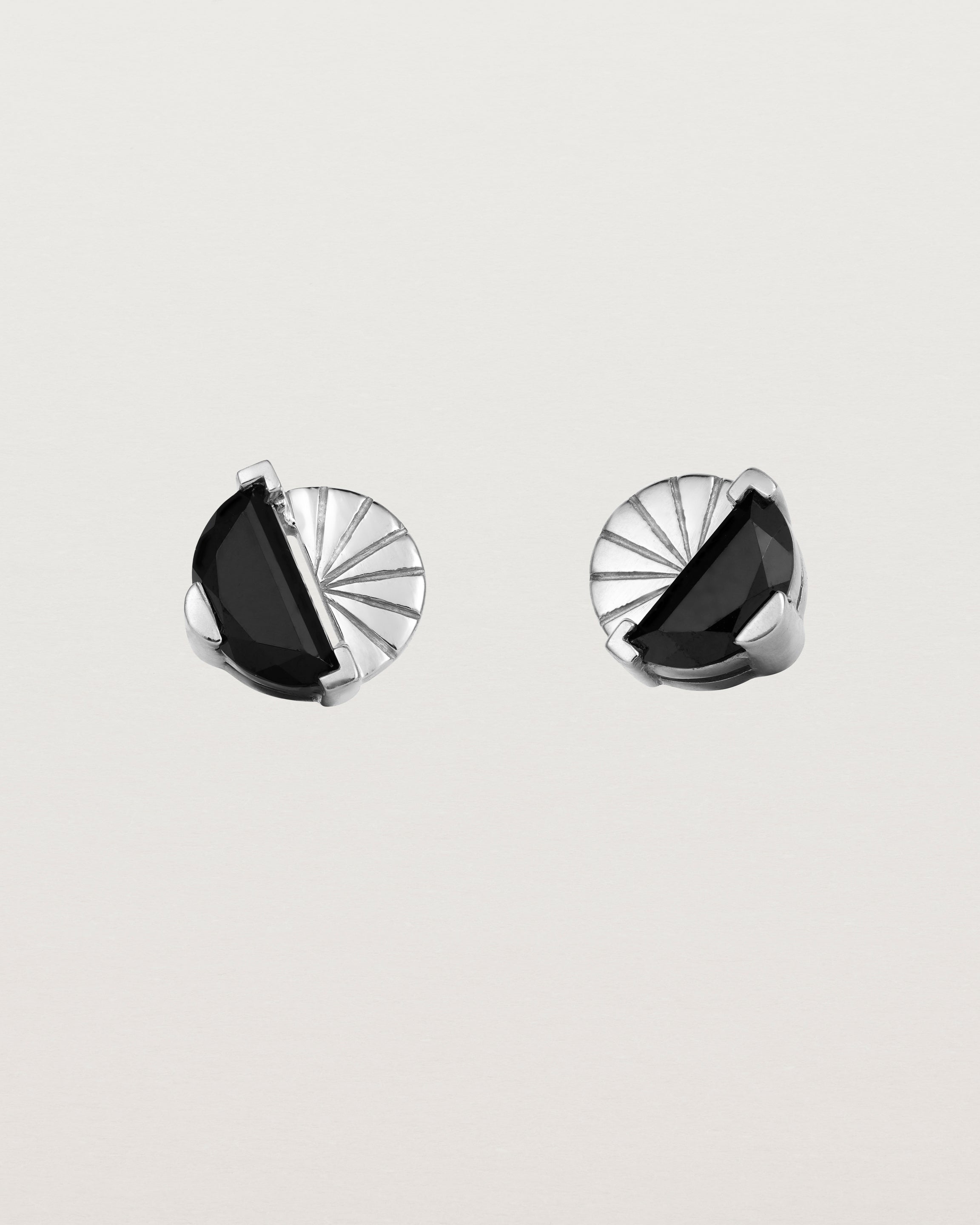 A pair of sterling studs featuring a half moon cut black spinel
