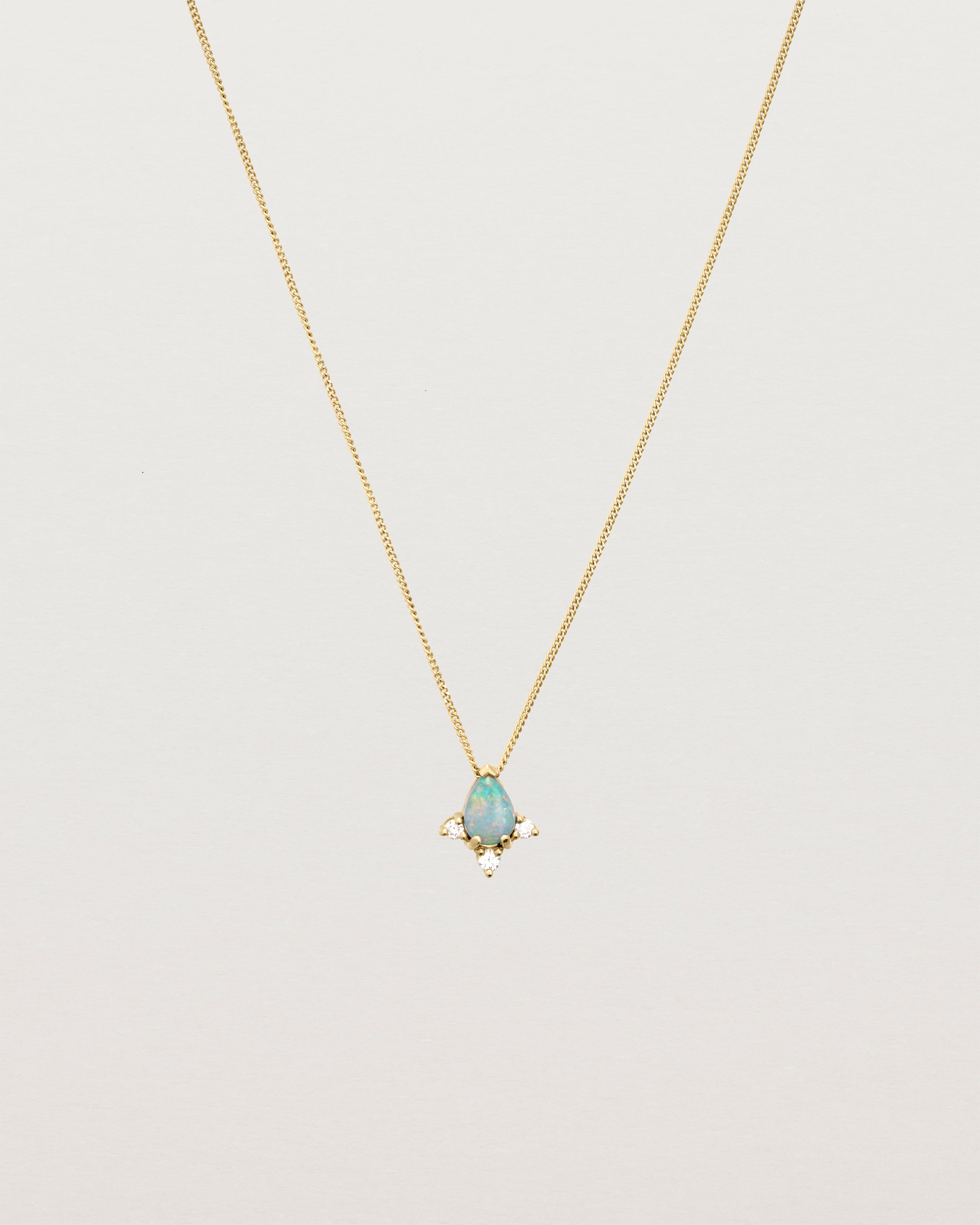A yellow gold necklace featuring a blue opal stone with three small diamonds