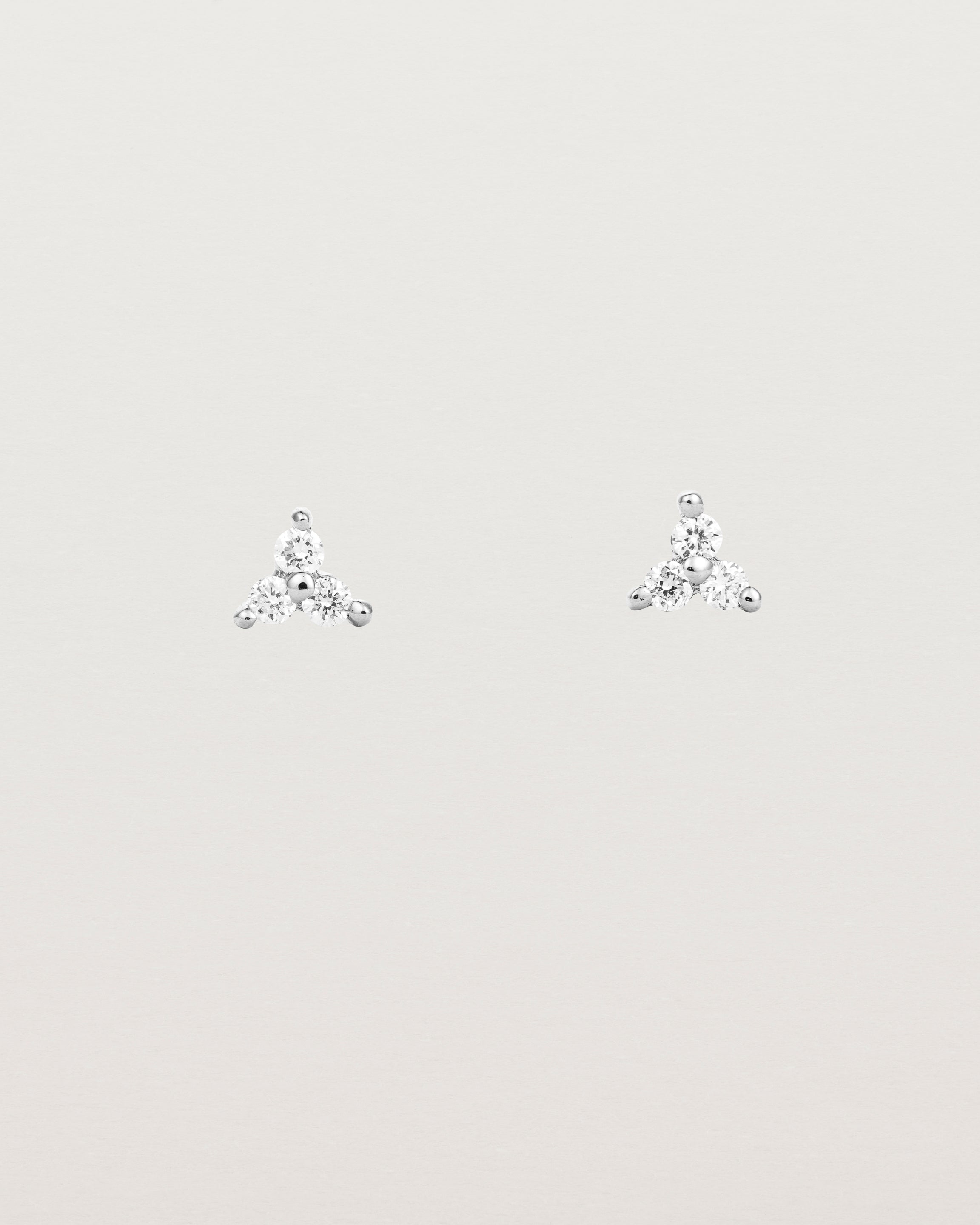 A pair of white gold studs with three small white diamonds.