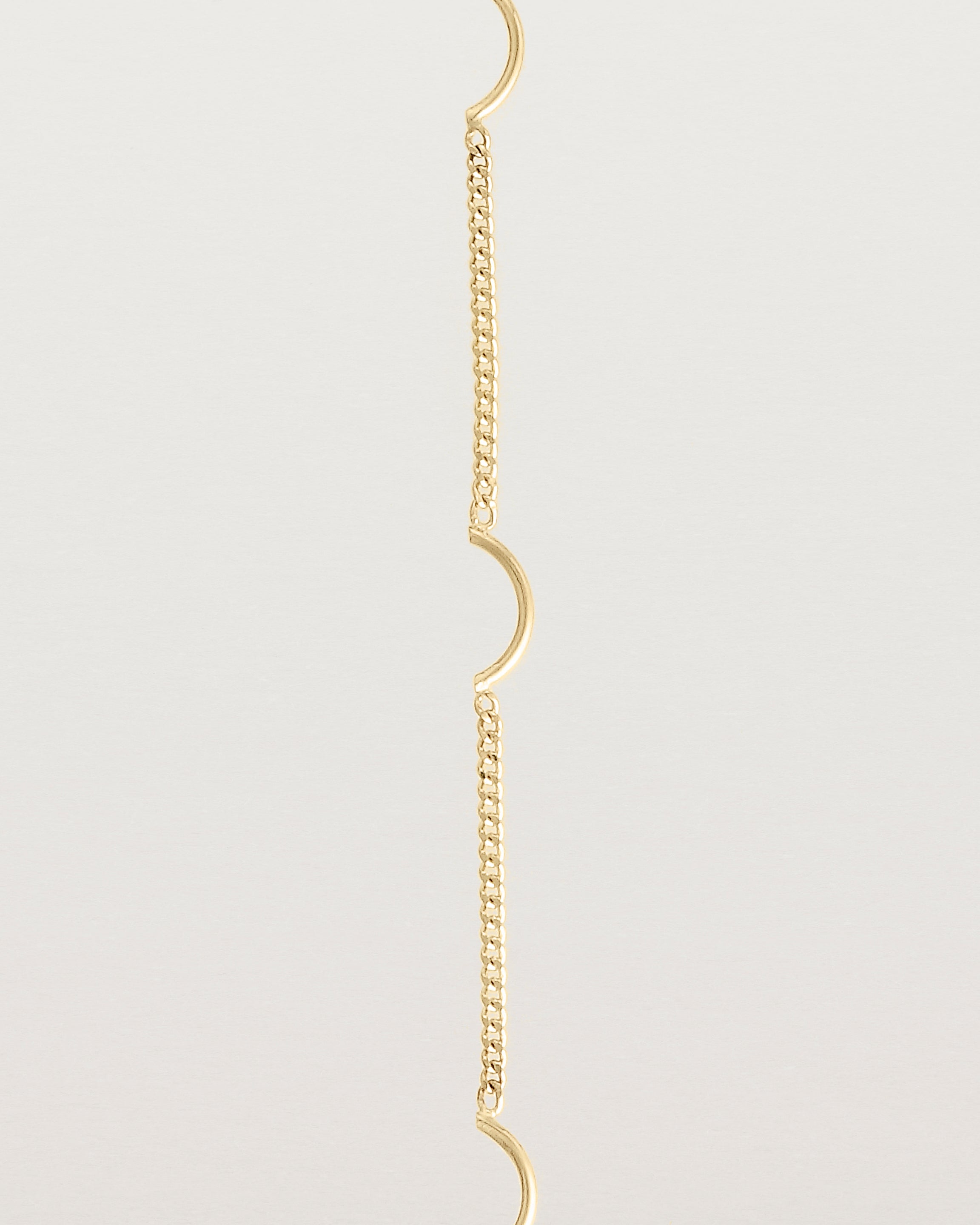 A yellow gold chain bracelet with five gold arcs
