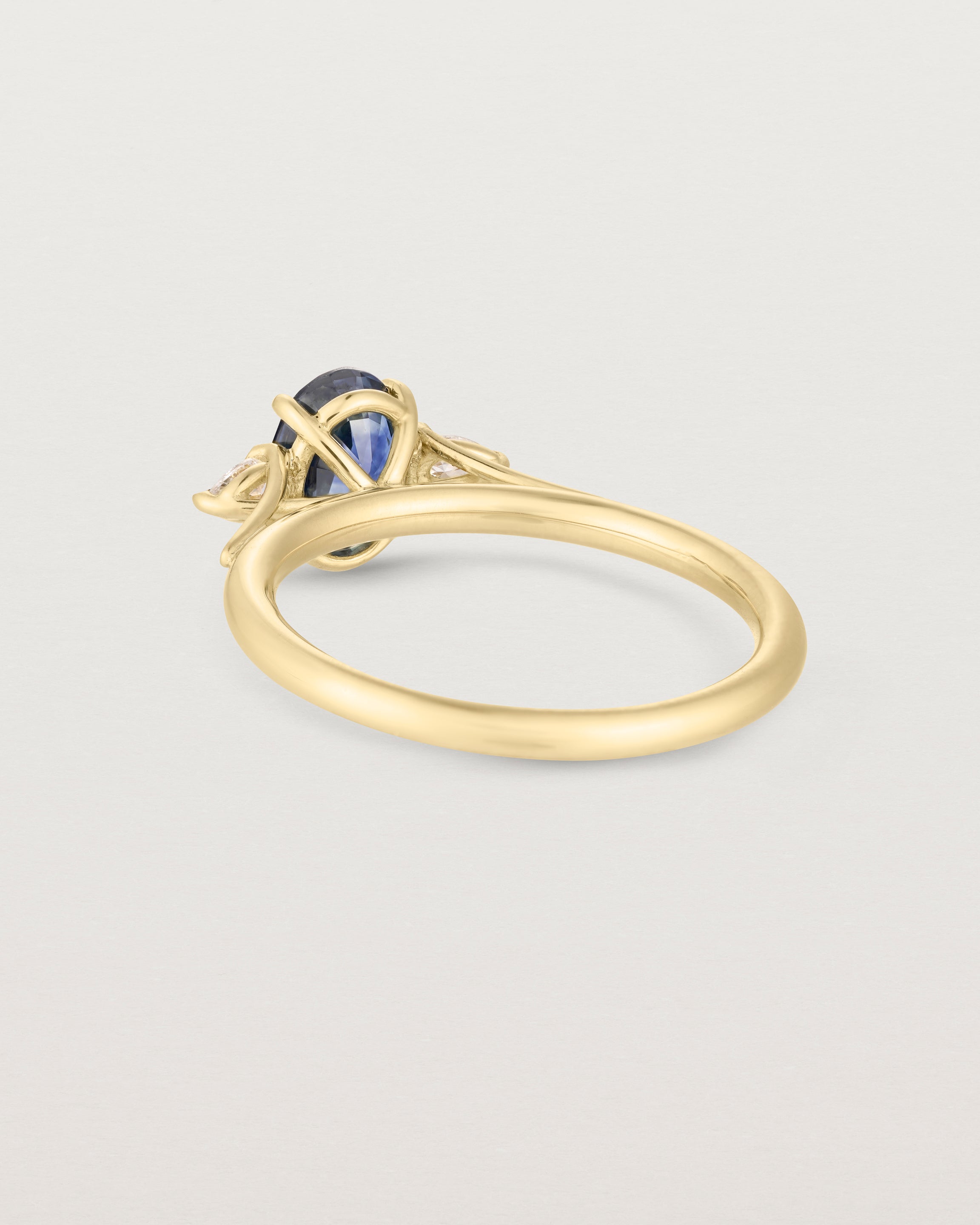 Back image of blue sapphire trio ring with white diamonds.