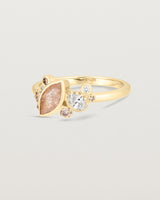 Product image of a yellow gold engagement ring with a rutilated quartz and diamonds, side view.