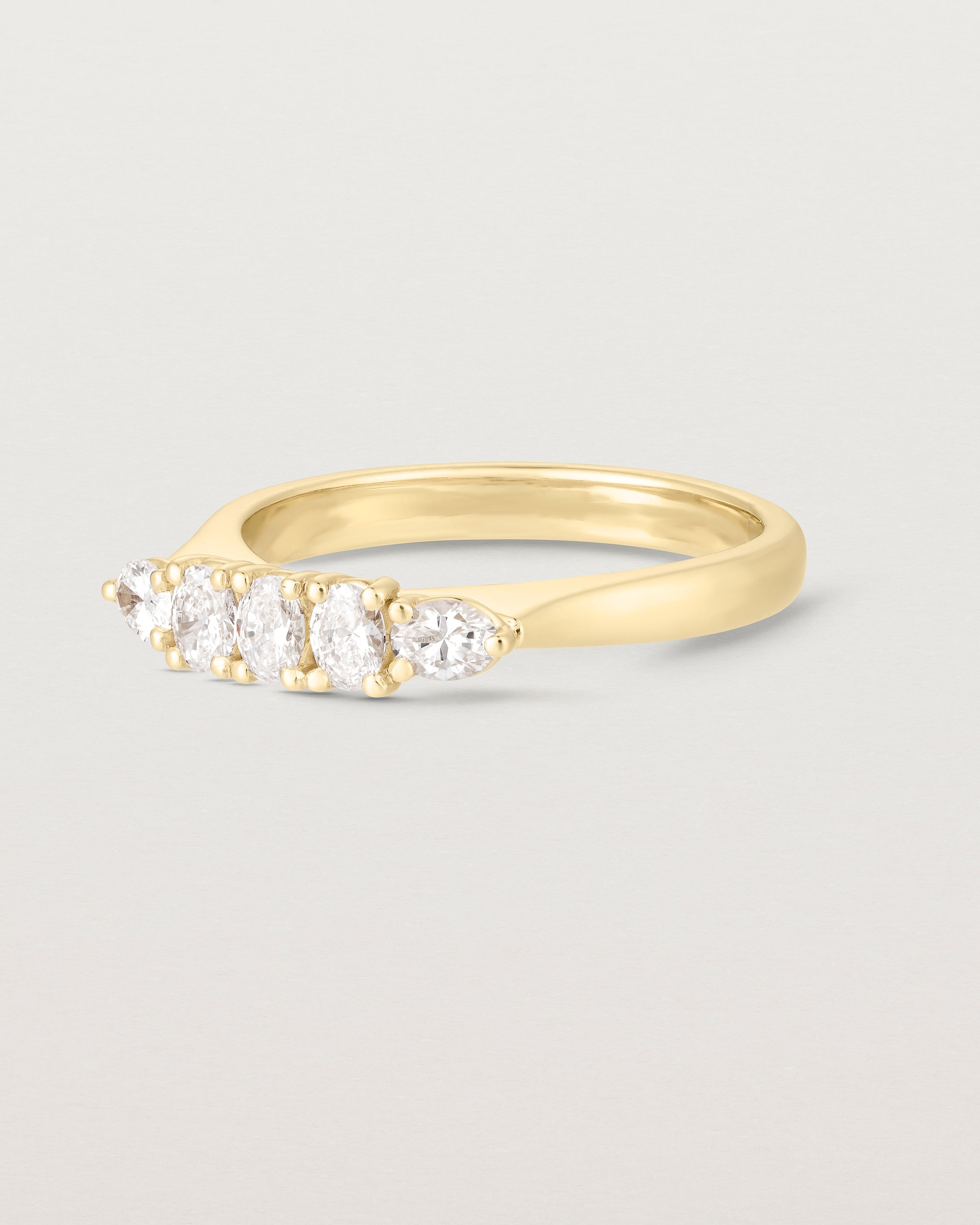 Side on image of diamond engagement ring in yellow gold. Featuring five white diamonds.