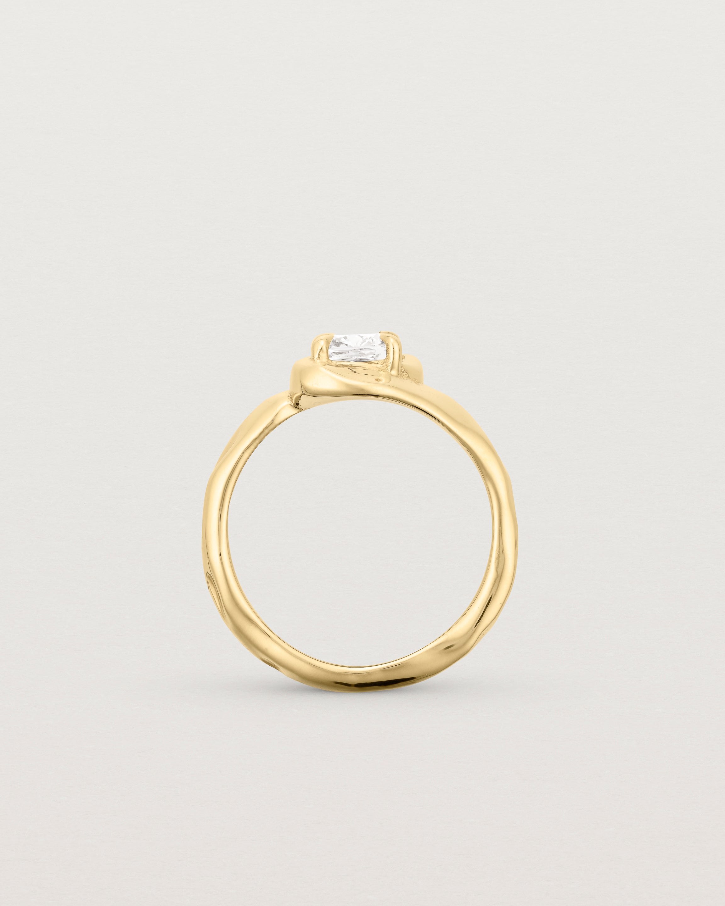 Standing deep etched image of a yellow gold solitaire engagement ring