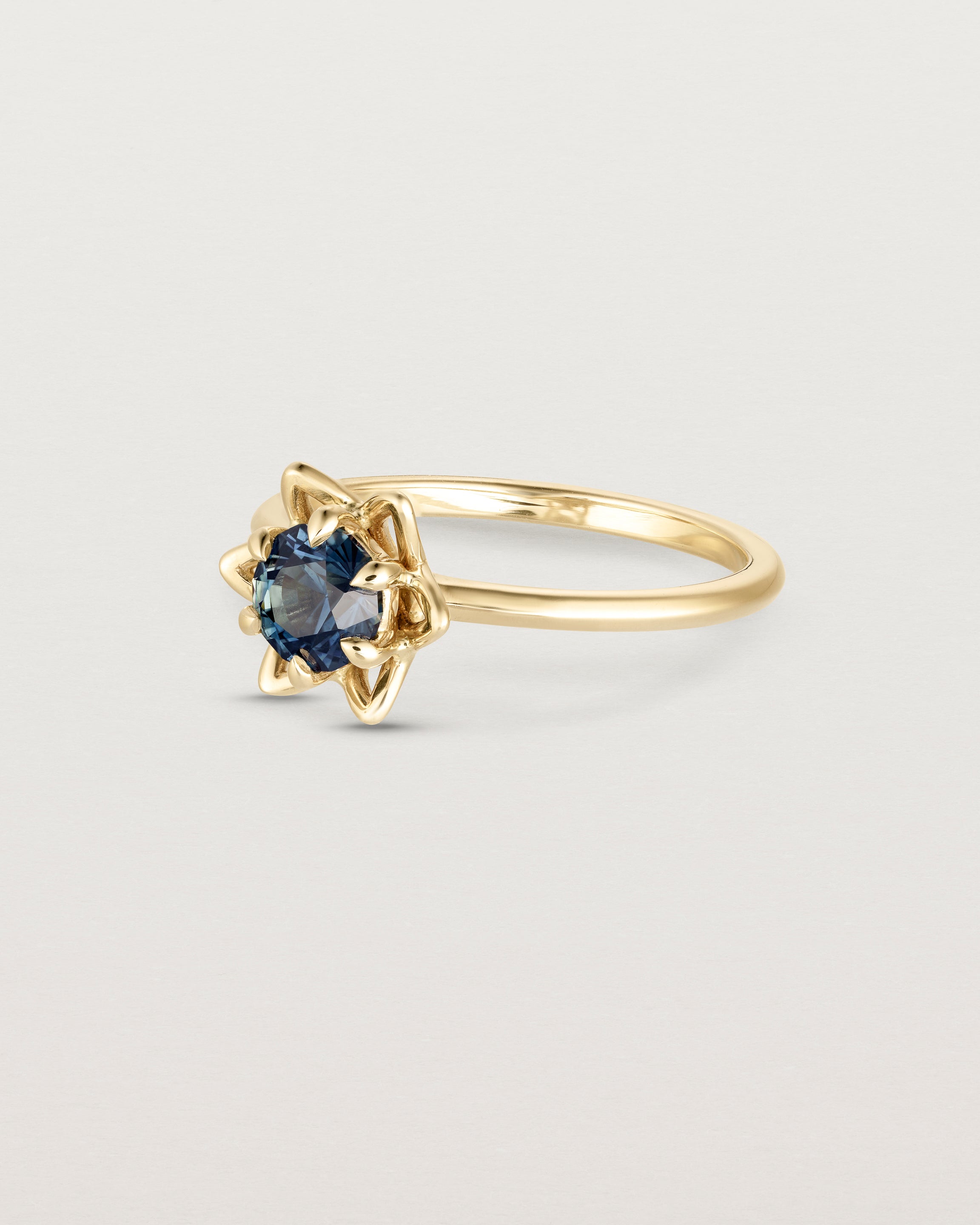 Side facing deep etched image of a Australian Teal Sapphire solitaire engagement ring.