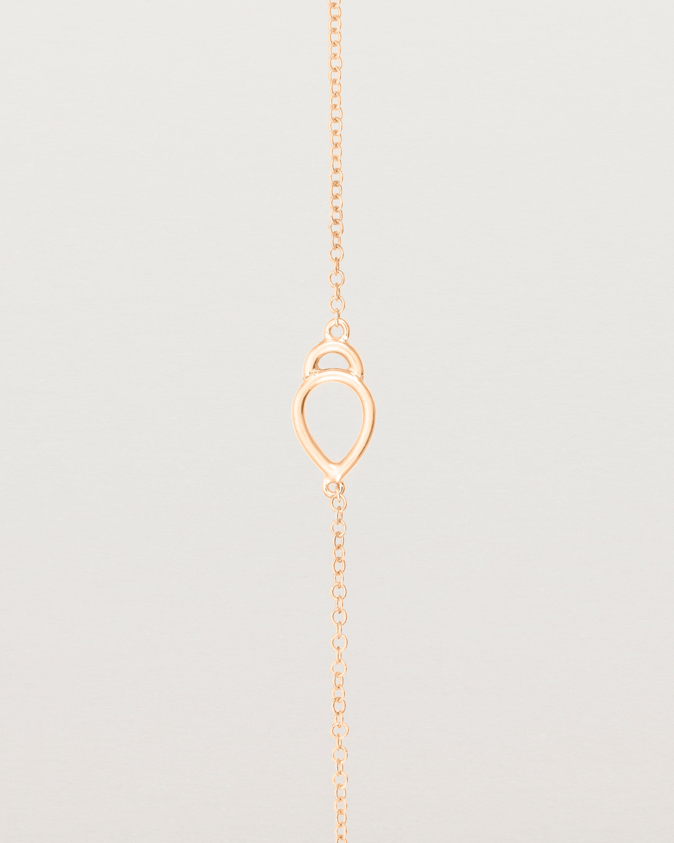 A rose gold chain with an oval pendant
