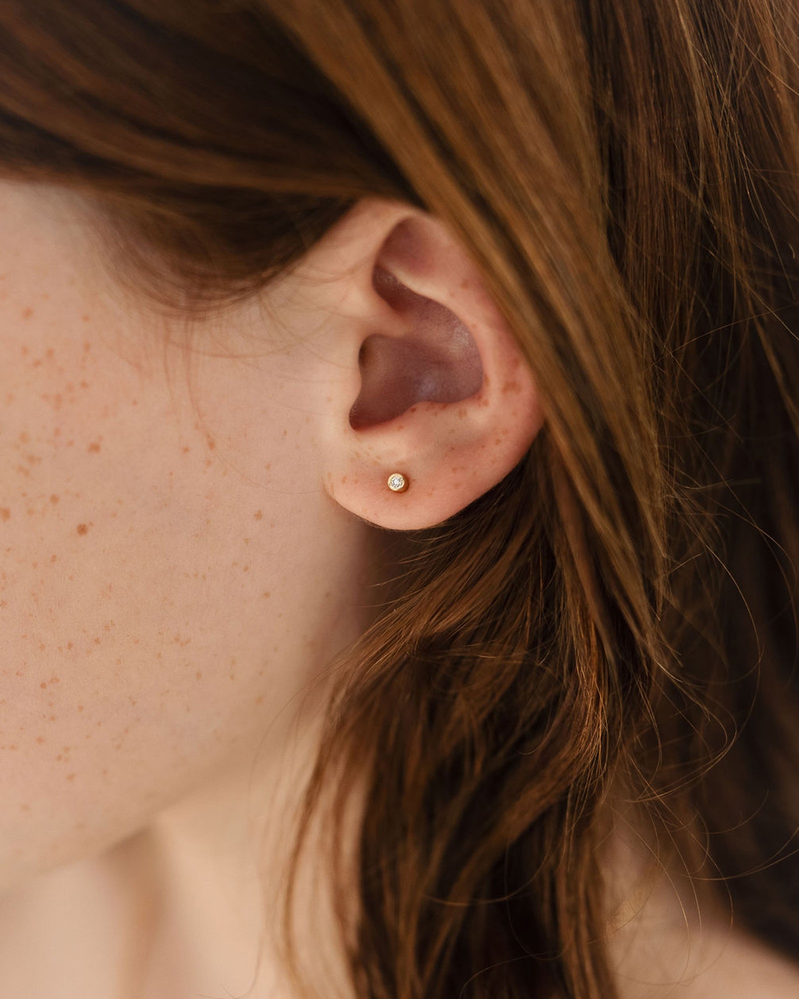 child model wearing the petits cascade studs in yellow gold