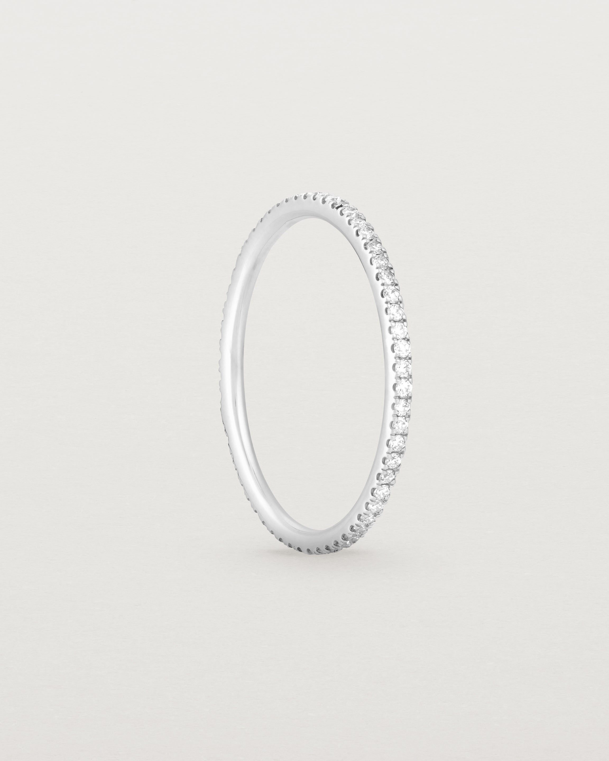 Standing view of a full white gold band featuring white diamonds