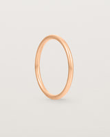 A side view of our fine round wedding band in rose gold
