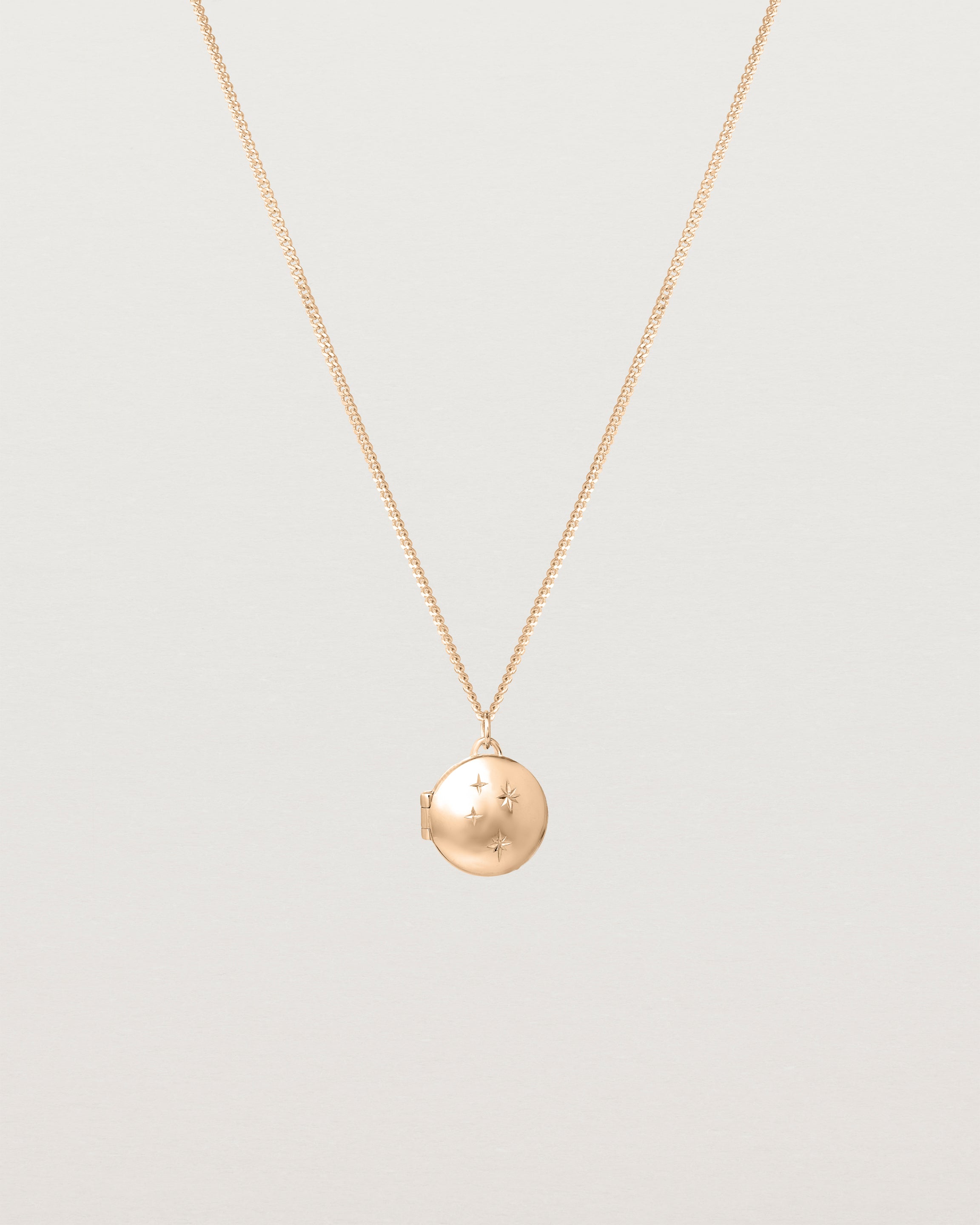 Front image of the starburst locket in rose gold.